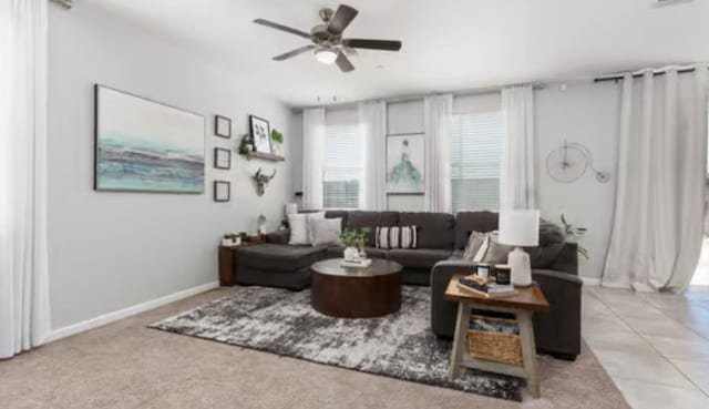 living area with baseboards and ceiling fan