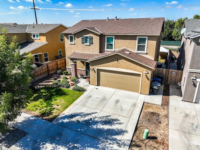 traditional-style home featuring a tile roof, fence, concrete driveway, a residential view, and stucco siding