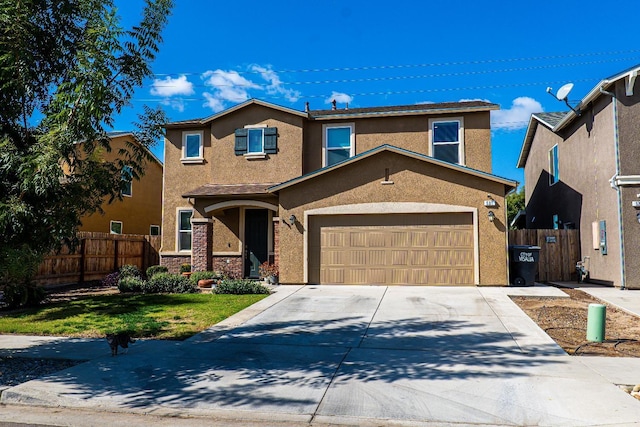 traditional home with a front yard, fence, concrete driveway, and stucco siding