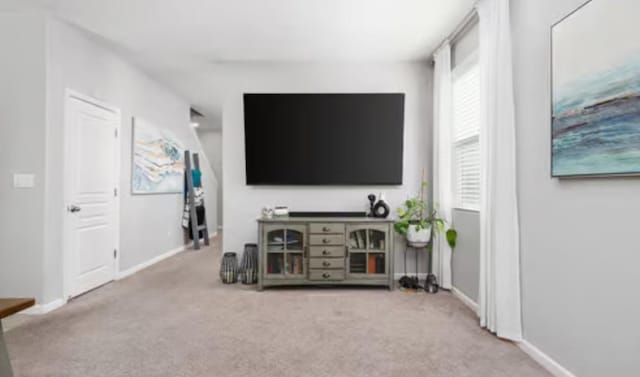 carpeted living area with baseboards