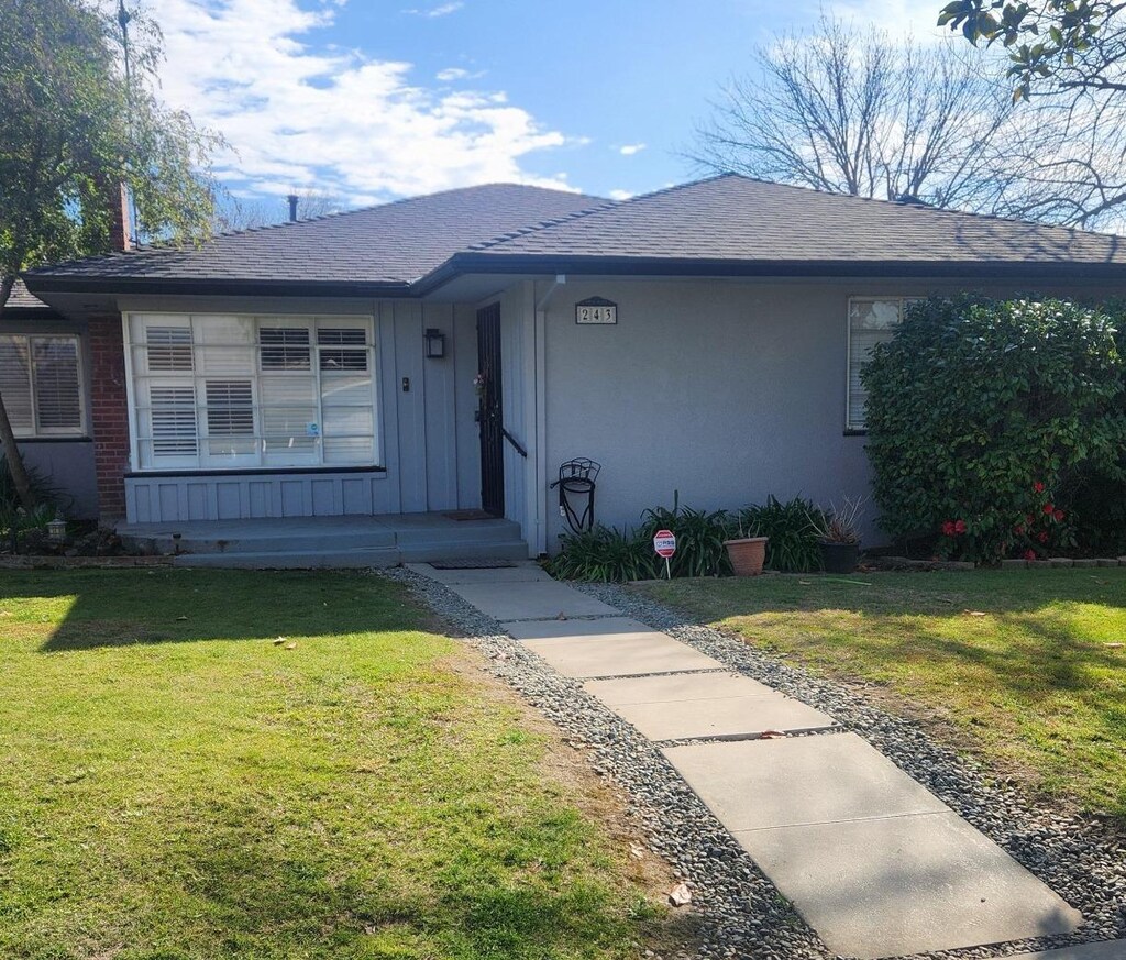 243 W Fountain Way, Fresno, CA 93705 - ranch-style home featuring board and batten siding, a shingled roof, and a front lawn