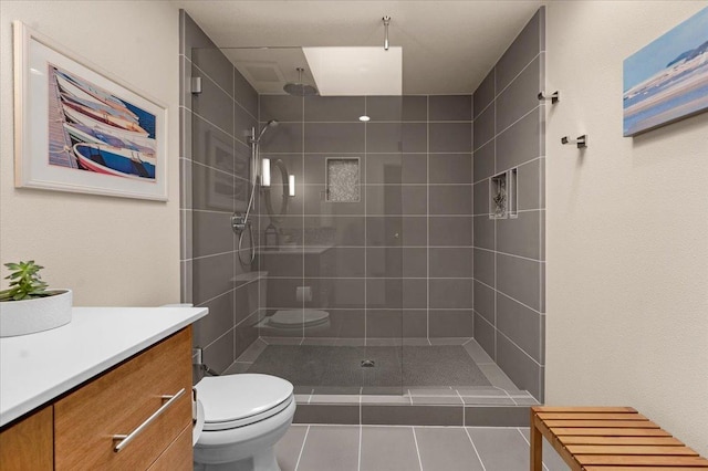 bathroom featuring tiled shower, vanity, and toilet