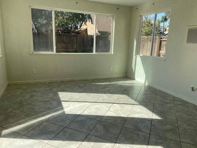 unfurnished room featuring light tile patterned floors and baseboards