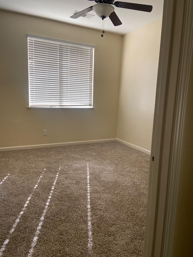 unfurnished room with a ceiling fan and baseboards