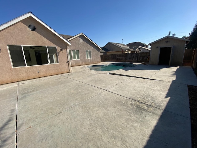 view of pool with an outbuilding, a shed, a fenced backyard, and a fenced in pool