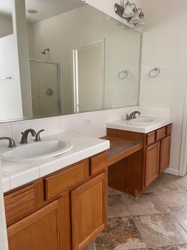 bathroom featuring double vanity, a shower stall, backsplash, and a sink