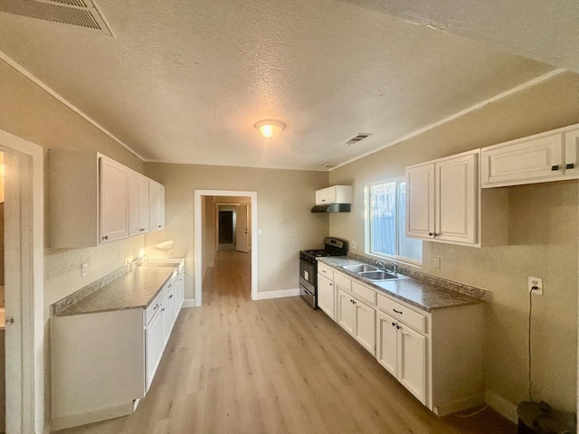 kitchen featuring light wood-style floors, stainless steel range with gas cooktop, white cabinetry, and a sink