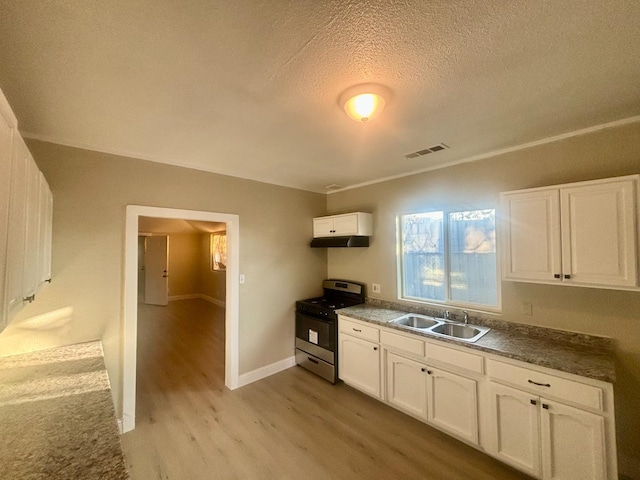 kitchen featuring visible vents, white cabinetry, a sink, light wood-type flooring, and stainless steel gas range oven