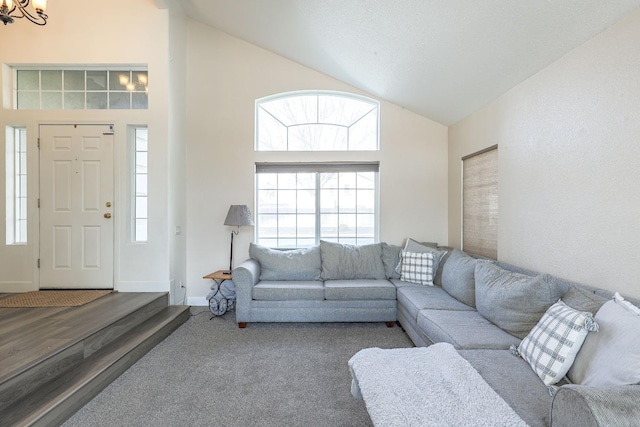 living room with high vaulted ceiling, baseboards, and a chandelier