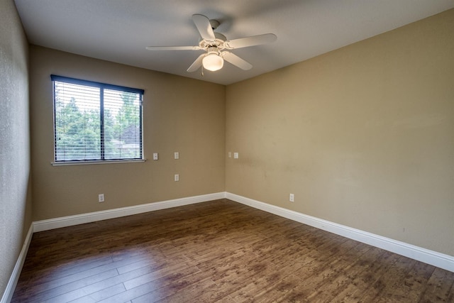 spare room featuring ceiling fan, baseboards, and dark wood finished floors