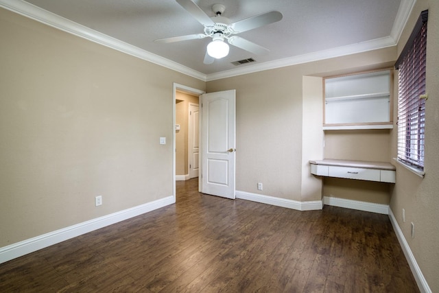 unfurnished bedroom with dark wood-type flooring, visible vents, baseboards, ornamental molding, and built in desk