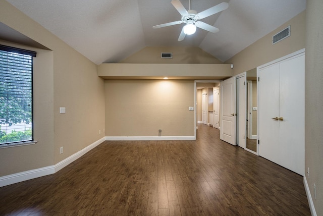 unfurnished bedroom featuring baseboards, visible vents, vaulted ceiling, and dark wood-style flooring