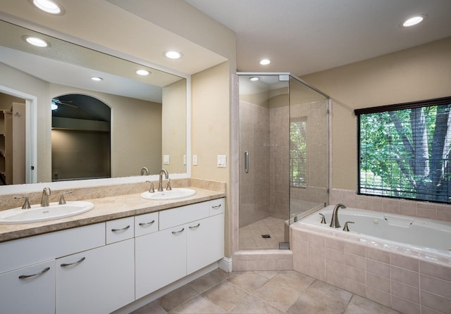 full bath with a stall shower, tile patterned flooring, a sink, and double vanity