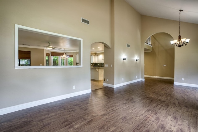 unfurnished living room featuring dark wood-style floors, baseboards, visible vents, and arched walkways