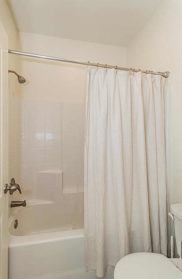 bathroom with shower / bath combo and toilet