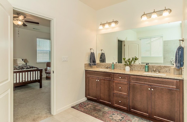 ensuite bathroom featuring tile patterned flooring, double vanity, a sink, and ensuite bathroom