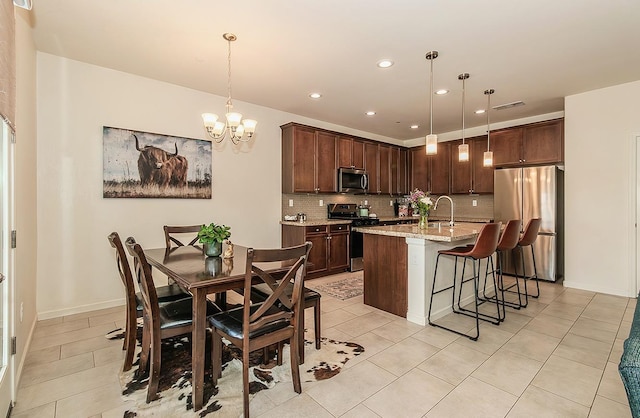 kitchen with light stone counters, visible vents, appliances with stainless steel finishes, decorative backsplash, and pendant lighting