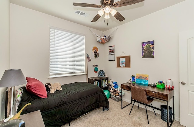 bedroom with light carpet, visible vents, and a ceiling fan