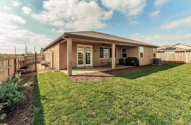 back of property featuring central AC unit, a lawn, a patio, a fenced backyard, and stucco siding