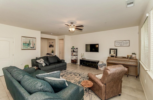 living area featuring ceiling fan, light tile patterned flooring, and visible vents