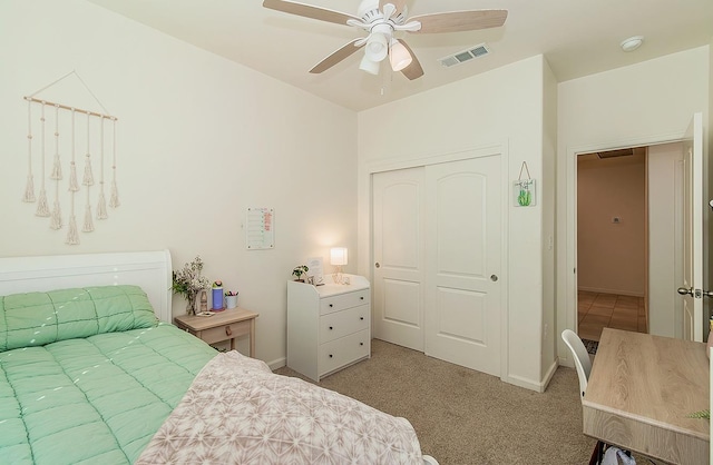 bedroom featuring light carpet, visible vents, baseboards, a ceiling fan, and a closet