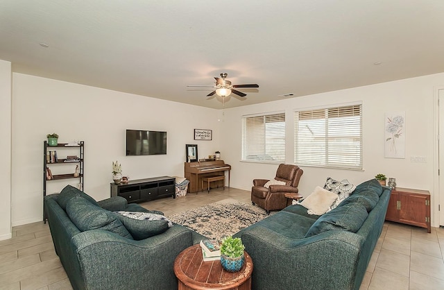 living room with light tile patterned floors, visible vents, and a ceiling fan