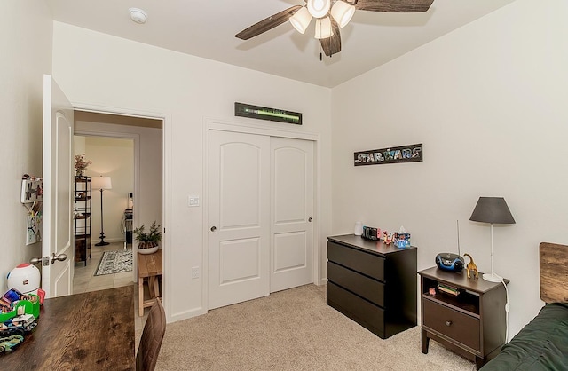 bedroom featuring ceiling fan, a closet, and light colored carpet