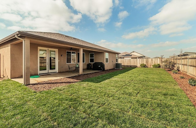 back of house with a patio, a lawn, a fenced backyard, and stucco siding