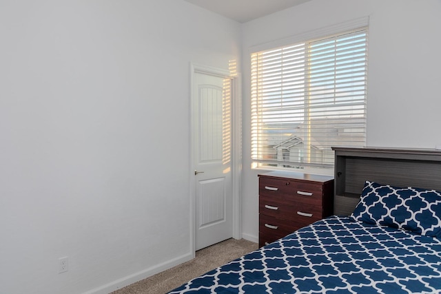 bedroom featuring baseboards and light colored carpet