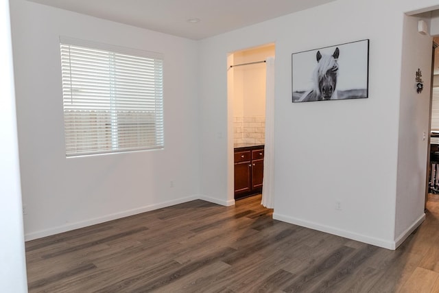 empty room featuring dark wood-style flooring and baseboards