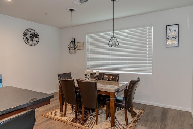 dining room with visible vents, baseboards, and wood finished floors