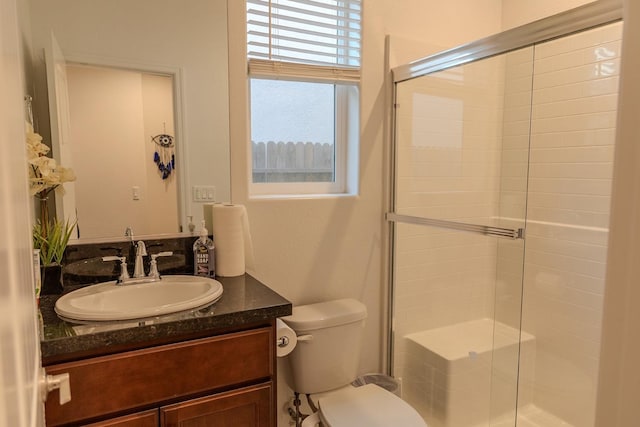 full bathroom with vanity, a shower stall, and toilet