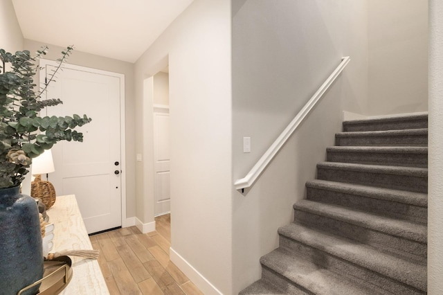 stairway with wood finished floors and baseboards