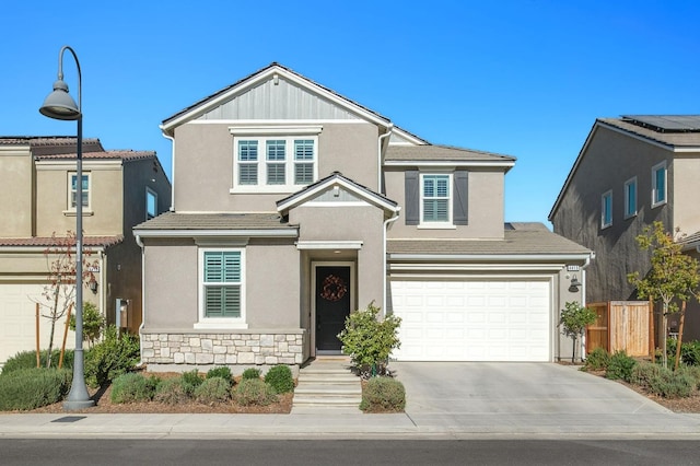 view of front facade featuring stucco siding, concrete driveway, fence, a garage, and stone siding