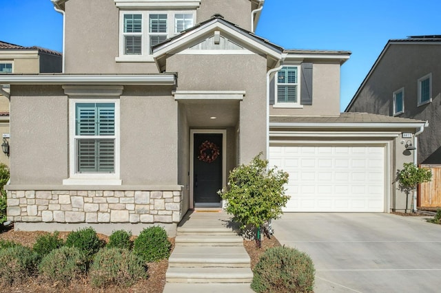 traditional-style home featuring stone siding, concrete driveway, and stucco siding