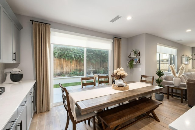 dining area with light wood-style floors, recessed lighting, and visible vents