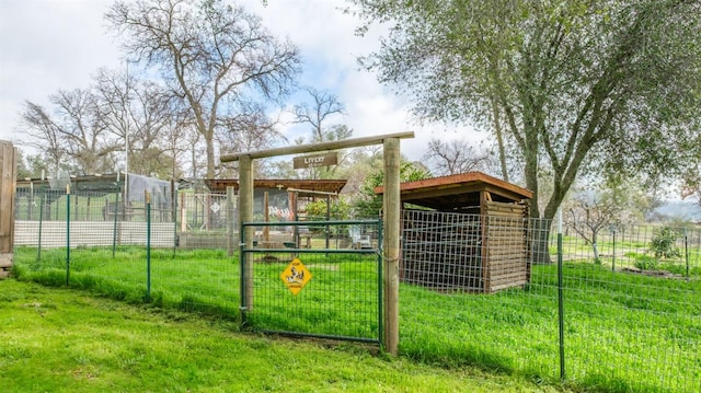 view of jungle gym featuring fence, a lawn, and an outbuilding