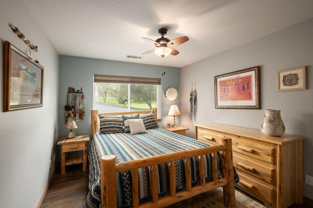 bedroom with dark wood-style floors, visible vents, and a ceiling fan