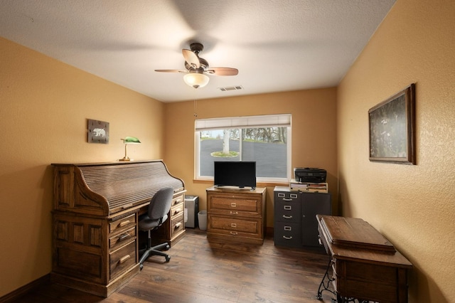 office area featuring dark wood-style floors, visible vents, a textured wall, ceiling fan, and a textured ceiling