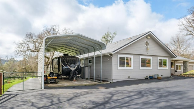 exterior space with a carport, driveway, fence, and a gate