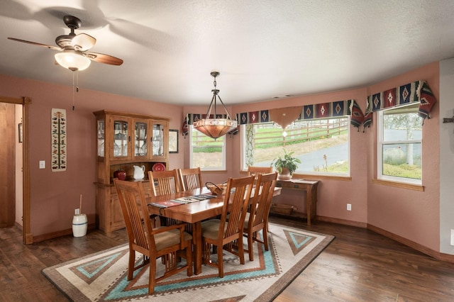 dining room with baseboards, dark wood finished floors, and a textured ceiling