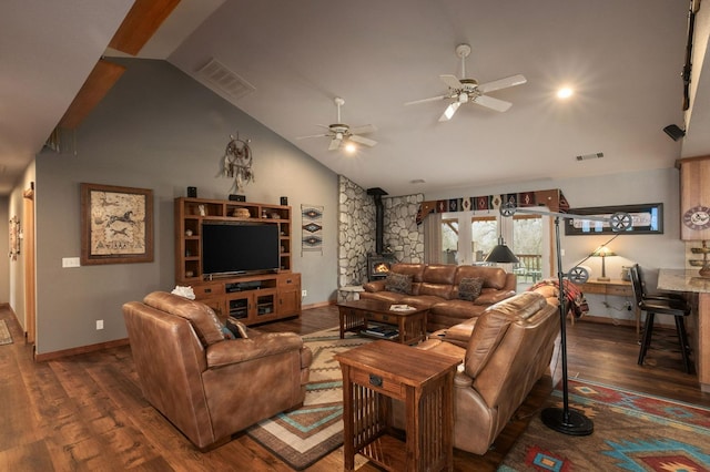 living area with a wood stove, visible vents, and dark wood-type flooring