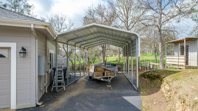 view of car parking featuring aphalt driveway and a detached carport