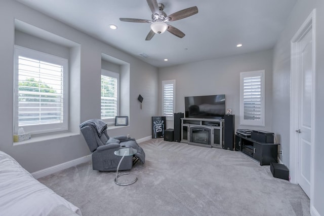 living room featuring a ceiling fan, recessed lighting, light colored carpet, and baseboards