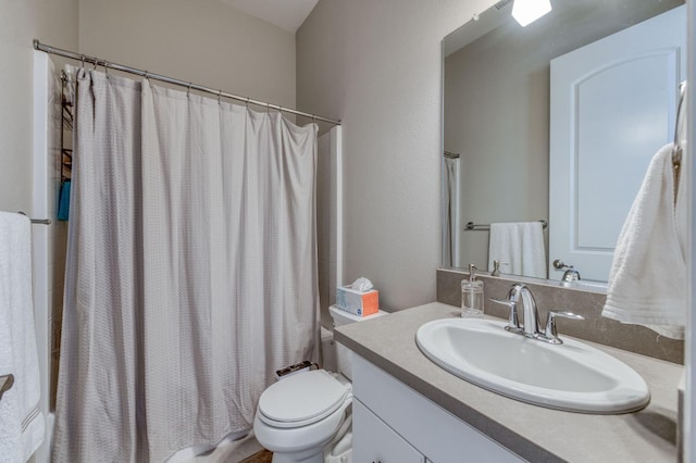 bathroom with shower / bathtub combination with curtain, vanity, and toilet