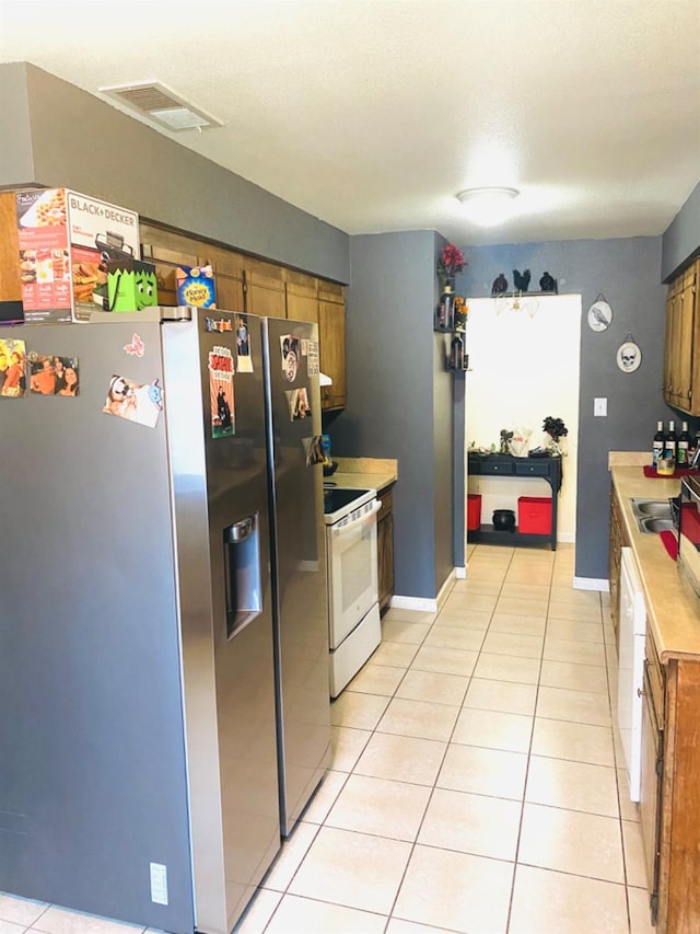 kitchen featuring light countertops, brown cabinetry, visible vents, and stainless steel fridge with ice dispenser