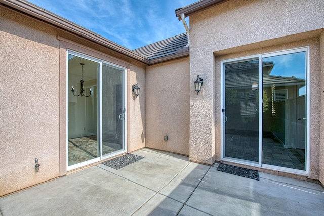 entrance to property featuring a patio area and stucco siding