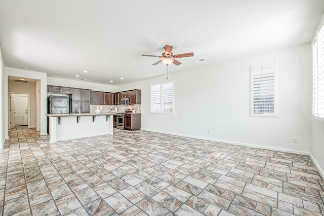 unfurnished living room featuring baseboards, recessed lighting, visible vents, and a ceiling fan