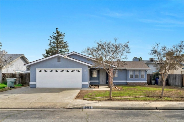 ranch-style home with a garage, fence, concrete driveway, stucco siding, and a front lawn