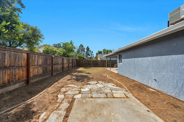 view of yard featuring cooling unit, a fenced backyard, and a patio